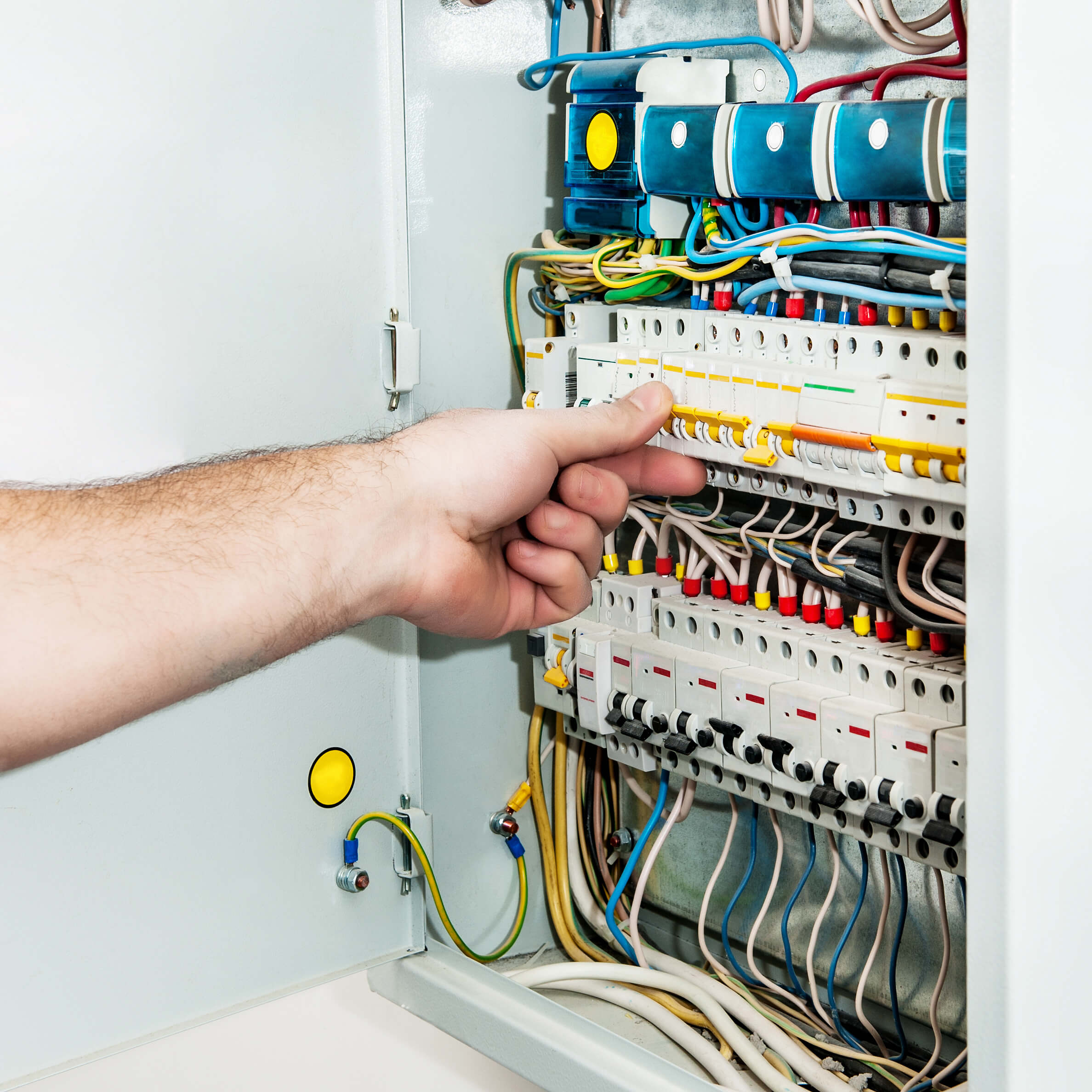 Hand adjusting wires in electrical panel.