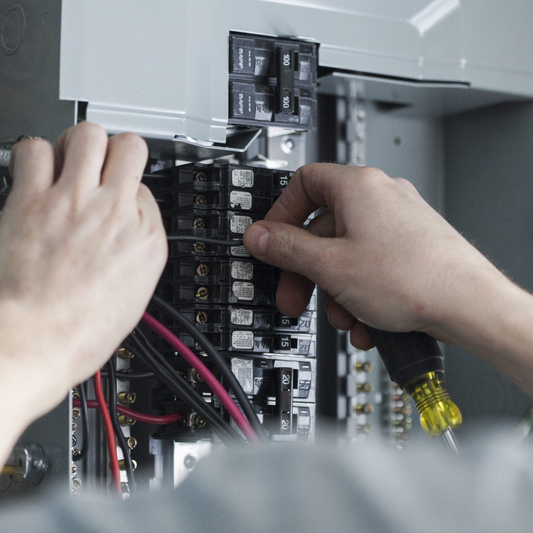 Electrician working on circuit breaker panel.